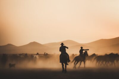 Cavaliers en silhouette au coucher du soleil, ambiance western