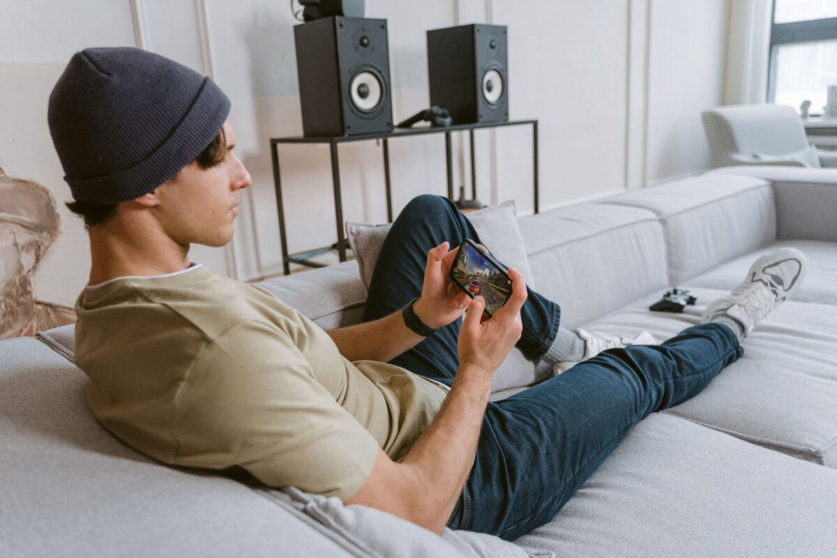 Joueur sur un canapé lançant un jeu en streaming sur son smartphone